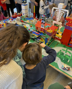Beispiel für Bausteinewelten - Mutter und Kind stehen vor einer aus Klemmbausteinen gebauten Stadt
