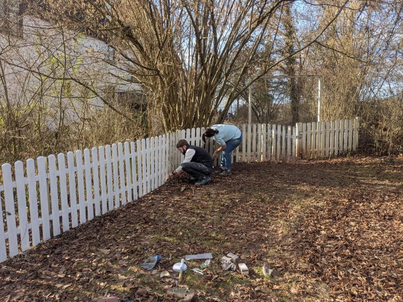 Zaun streichen beim Einsatztag im Knüll House